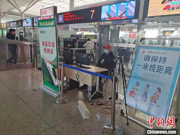 图为郑州东站工作人员正在对进出站旅客实时测温。　赵依婷 摄